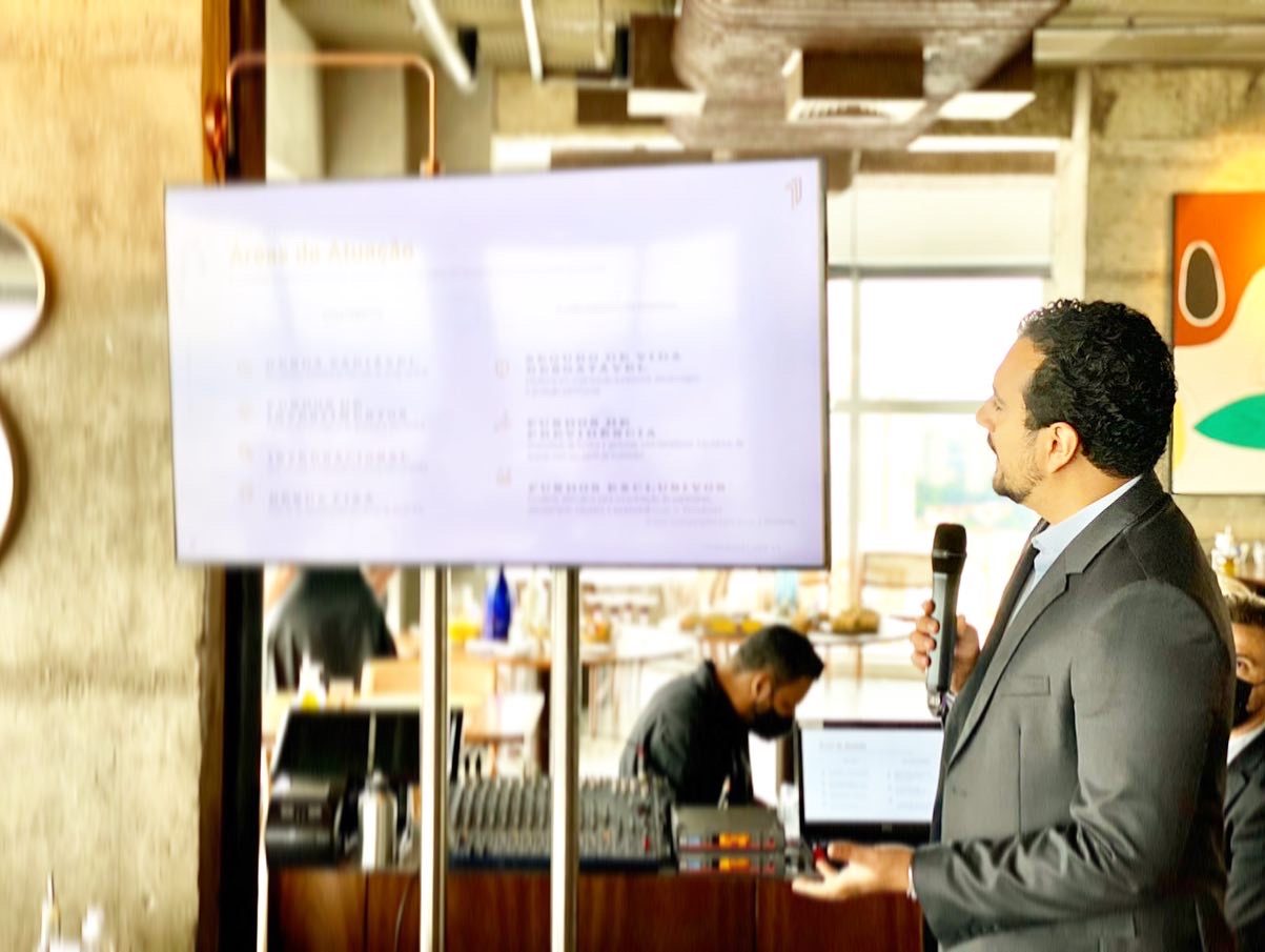 Guilherme Gomes apresentando as áreas de atuação em evento presencial